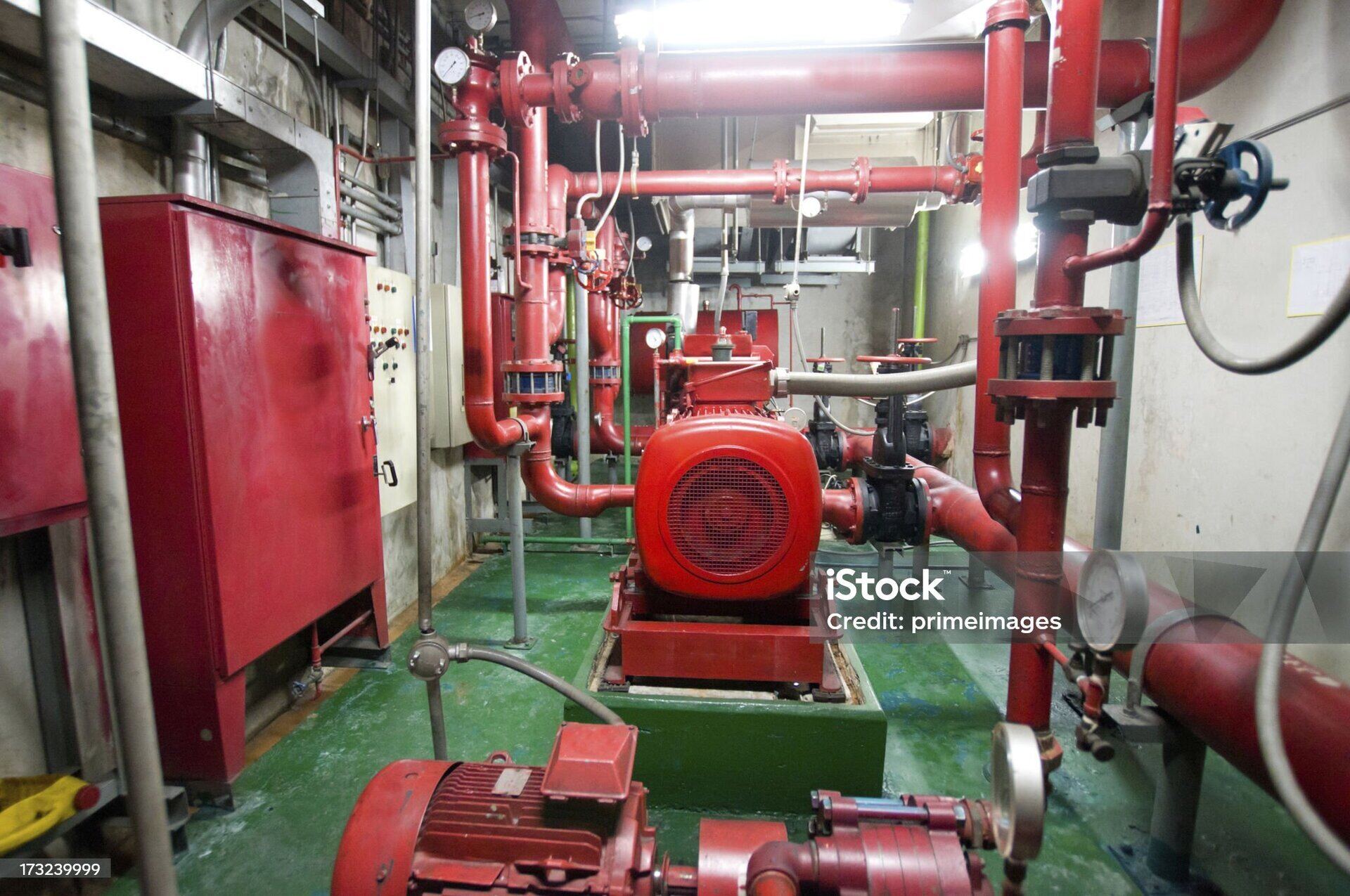 Engine room with red fire pumps and pressure gauges